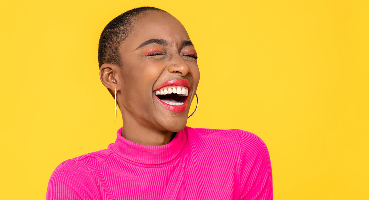 Happy optimistic African American woman in colorful pink clothes